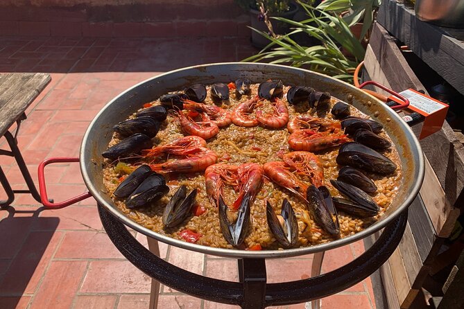 Rooftop Paella Seafood Cooking Class Experience in Barcelona - Cooking on a terrace with plants, and eating at sunset